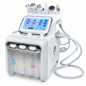 White six-in-one facial system with touchscreen, six handpieces and three clear bottles on a clean white background.