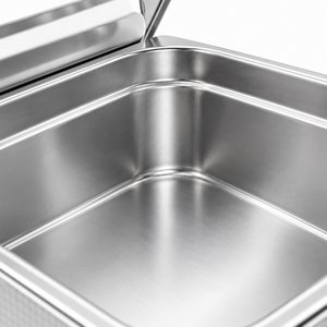 Close-up of the empty stainless steel tank and polished rim, with the removable lid behind it.