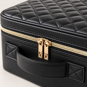 Close-up of the makeup case double gold zip pullers and stitched edge
