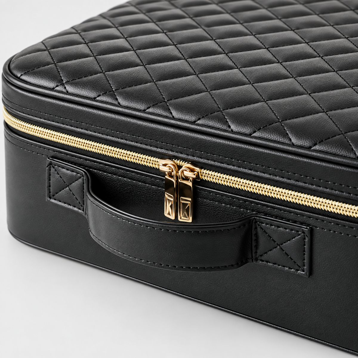 Detail of the black carry handle and stitched attachments on the makeup case
