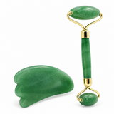 Green facial roller and gua sha on a white background