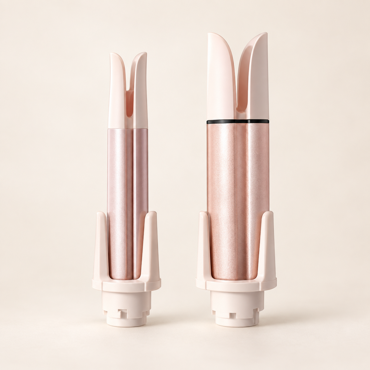 The two spare interchangeable 28mm and 32mm curling barrels in pink and rose gold.