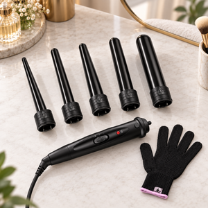 Complete black curling wand set with five ceramic barrels and glove arranged on a dressing table.