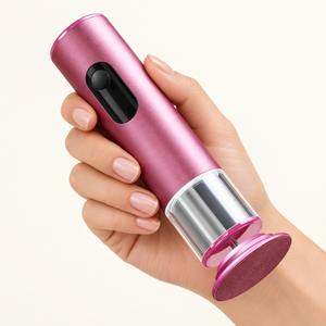Hand holding the pink rechargeable foot file to show its compact handheld format.