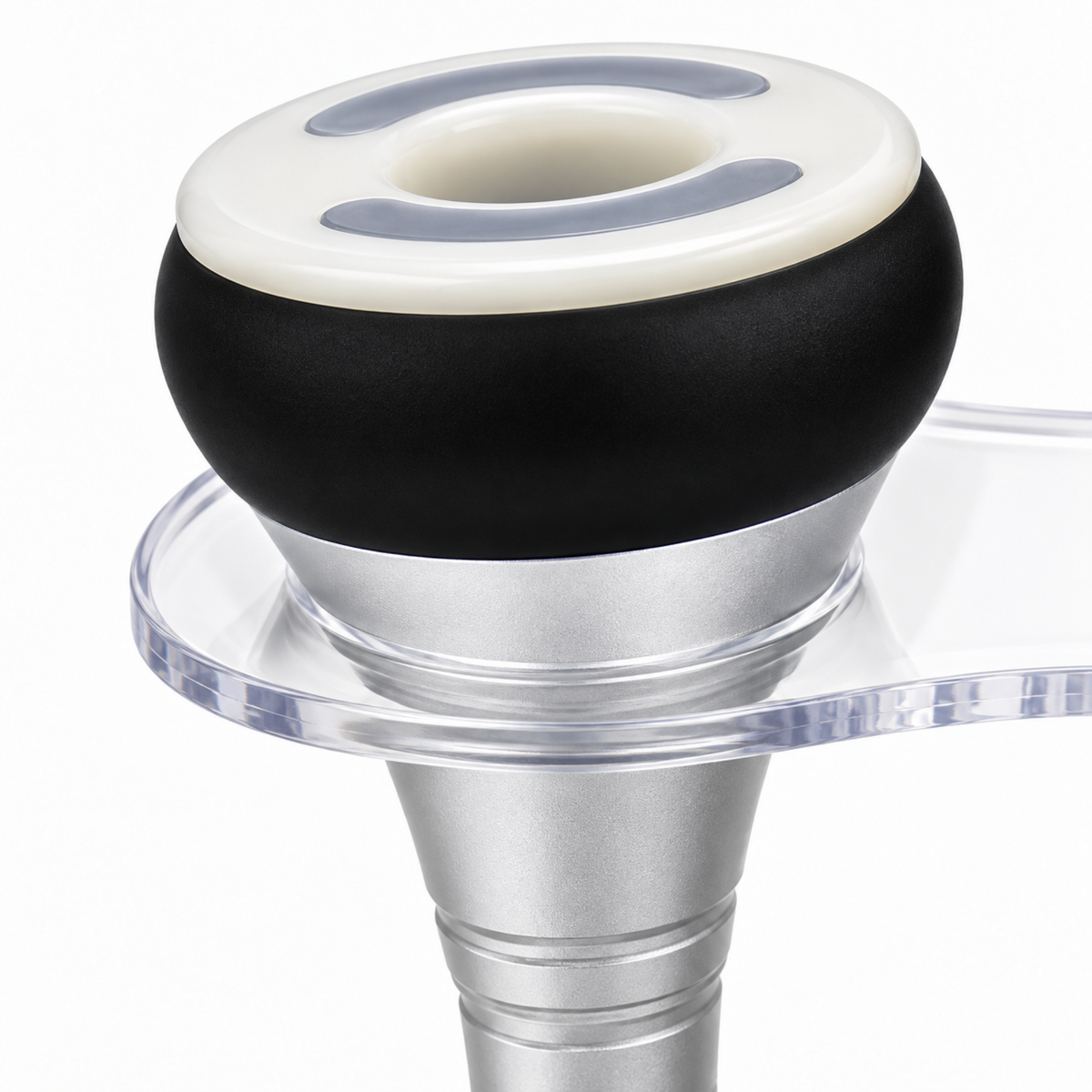 Detail of the vacuum handpiece showing its white rim, hollow centre, black collar and silver handle.