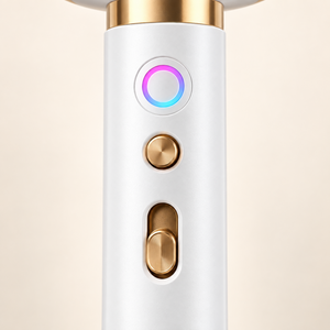 Close-up of the hair dryer handle showing its light indicator and gold controls
