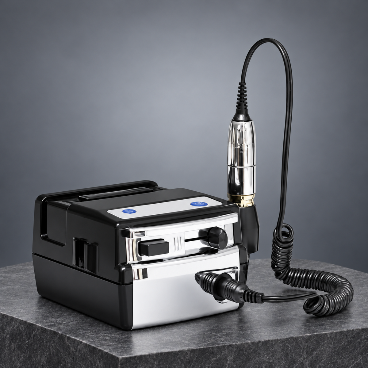 Electric nail drill with coiled handpiece cable displayed on a grey stone plinth