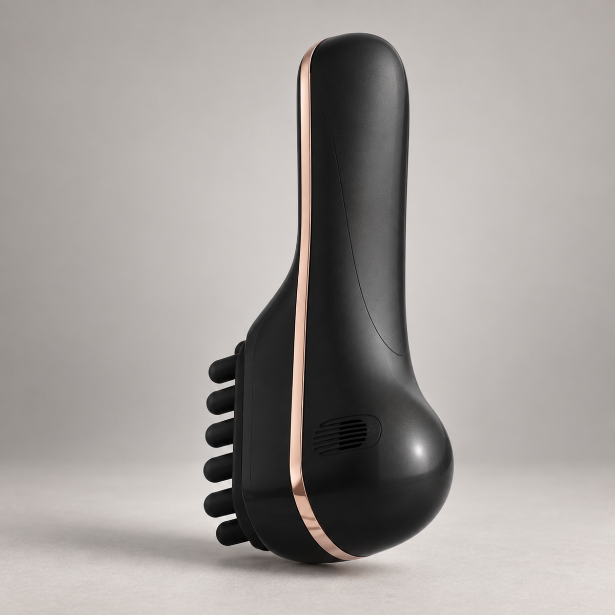 Black scalp massage comb showing its soft silicone head and metallic trim from a side angle.