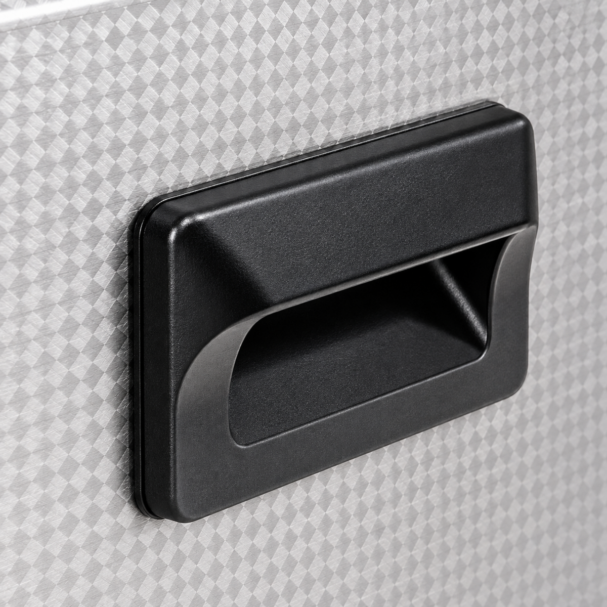 Close-up of the black recessed carrying handle and textured stainless steel housing.
