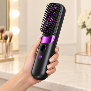 Black hair straightening brush held in one hand, showing its handle and brush head