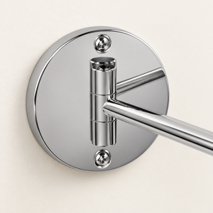 Close-up of the chrome wall mounting plate and two fixing screws
